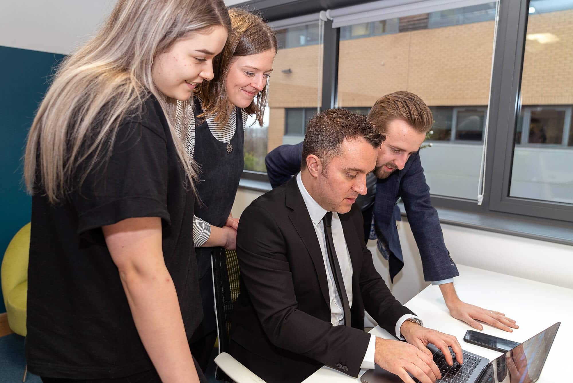 Members of the Hope Park team collaborating around a laptop
