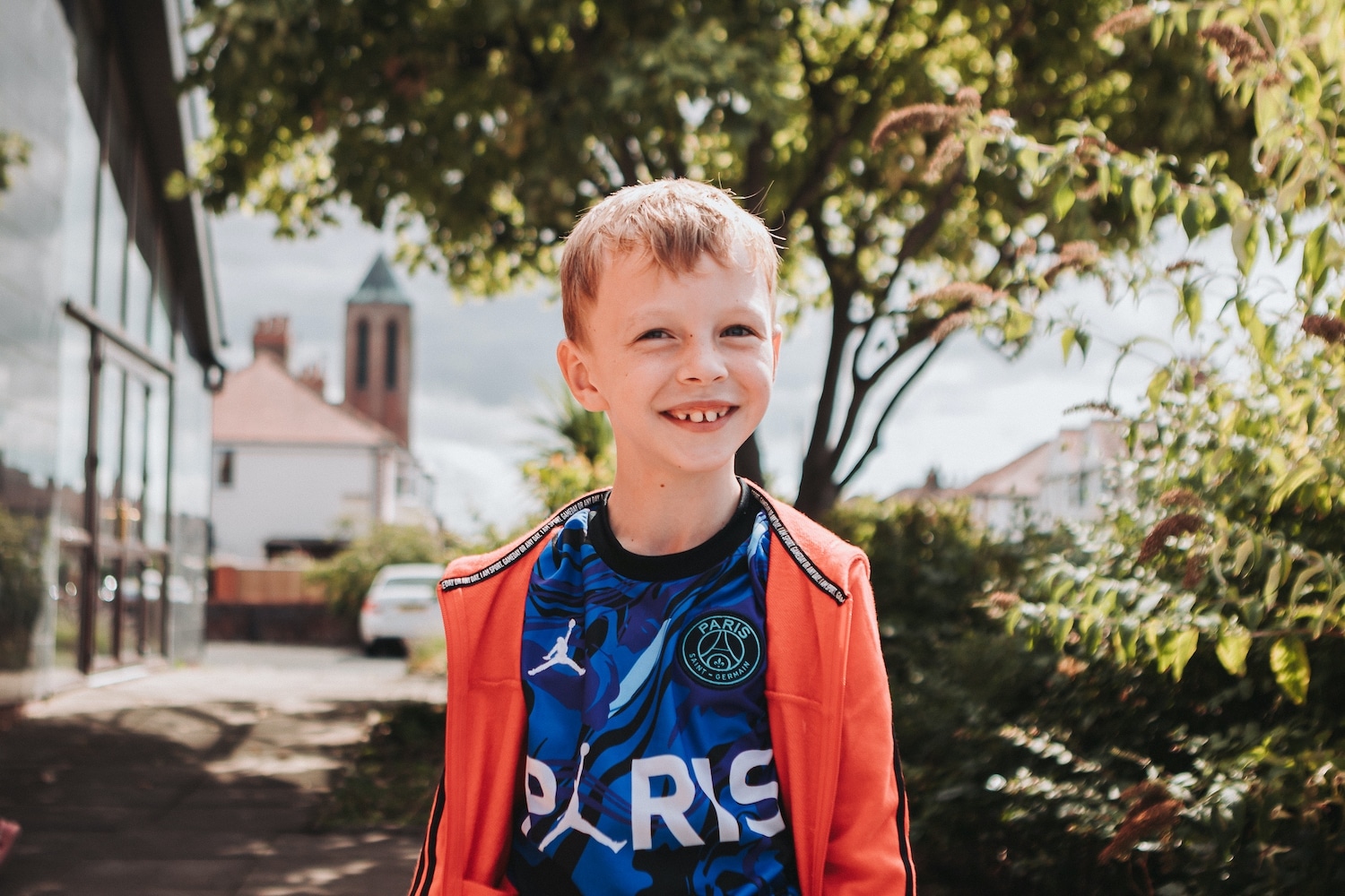 A young boy smiling outside, supported through Transforming Lives for Good