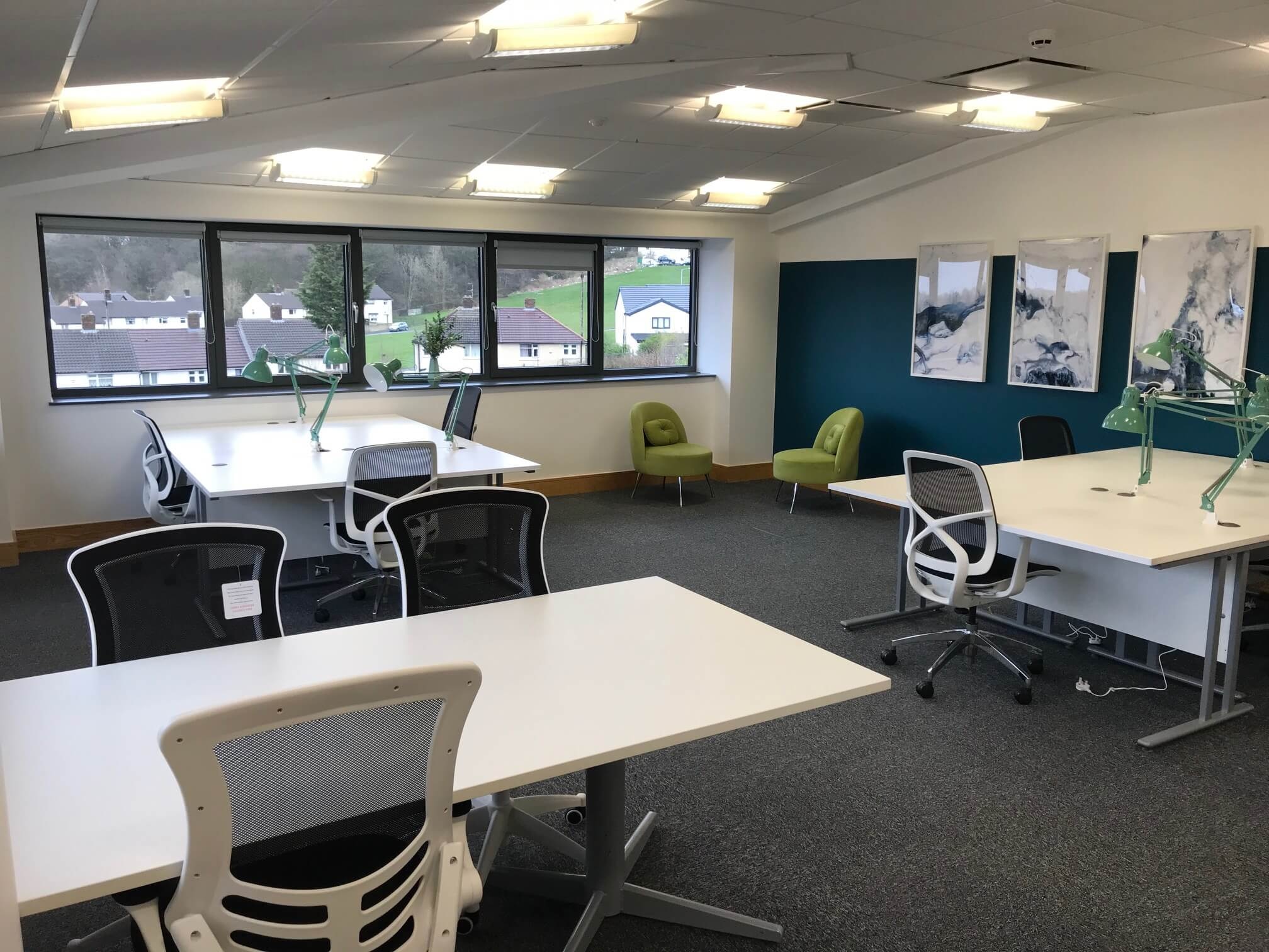 A bright, open-plan serviced office at Hope Park with desks, task lighting, breakout chairs and countryside views